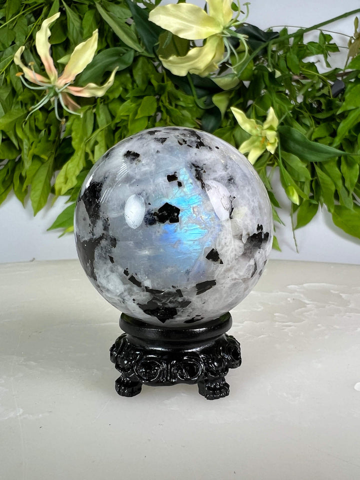 Maansteen bol 1 met blauwe flash op zwarte bolhouder design met pootjes.