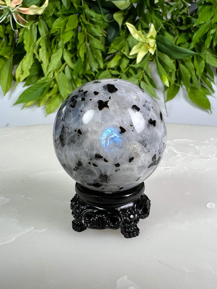 Maansteen bol 3 met blauwe flash op zwarte bolhouder design met pootjes.