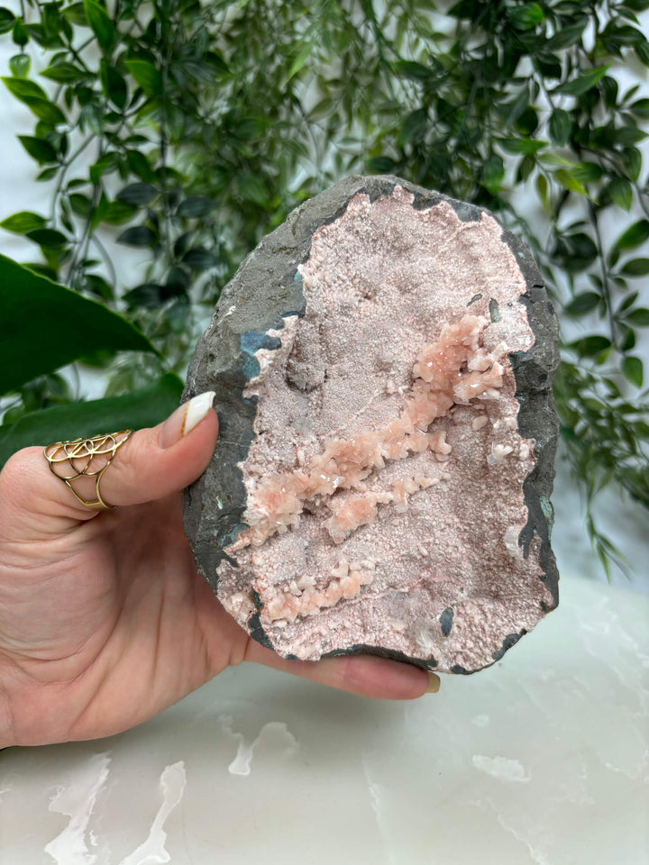 Voorkant van de heulandiet geode 3 met handen.